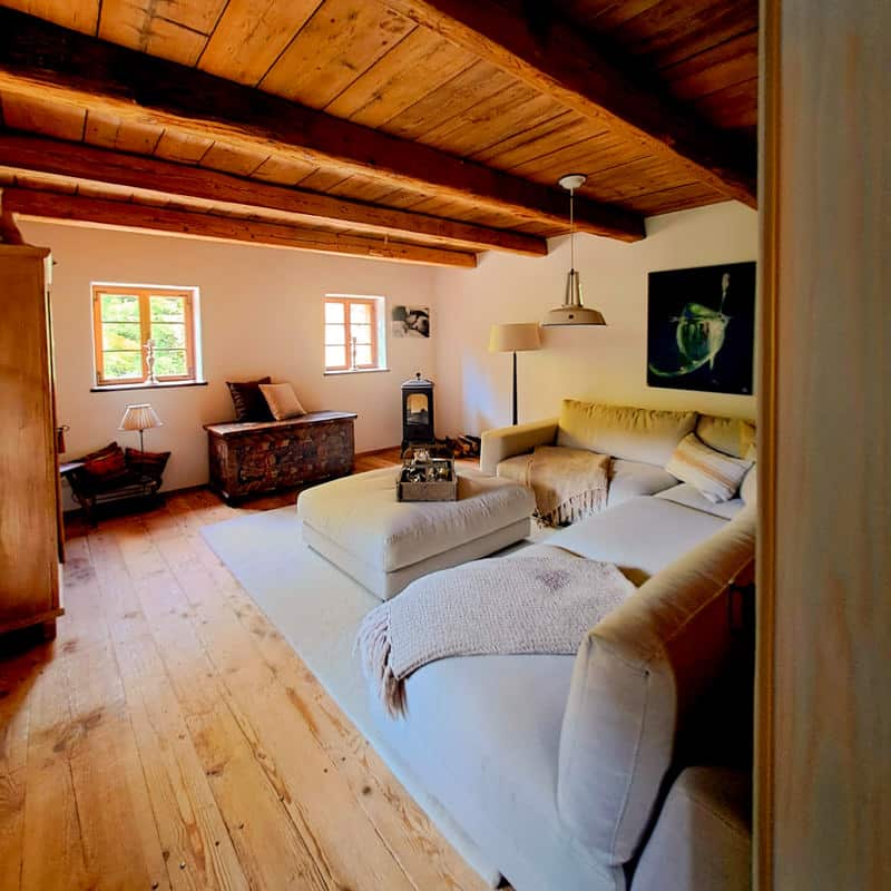 Gemütliches Wohnzimmer mit Holzdecke und Naturmaterialien – Raumdesign von Gabriele Musger